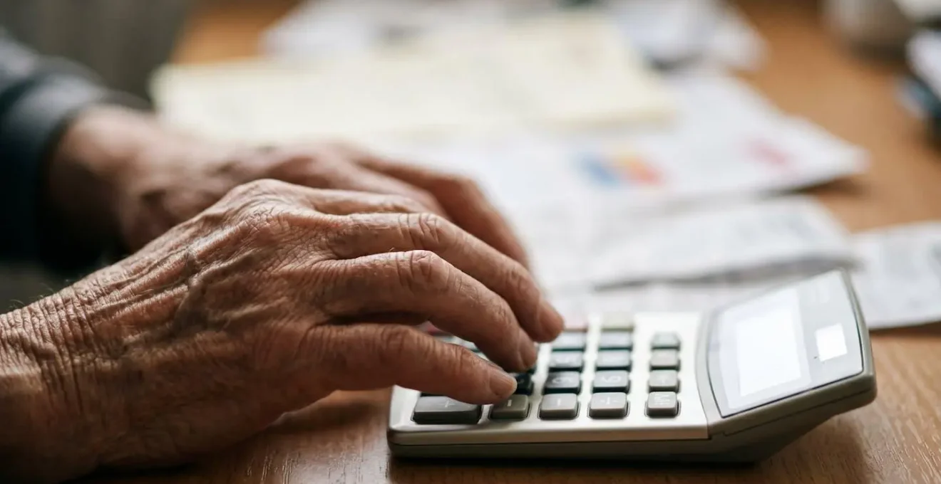 Gros plan sur des mains utilisant une calculatrice avec des documents médicaux