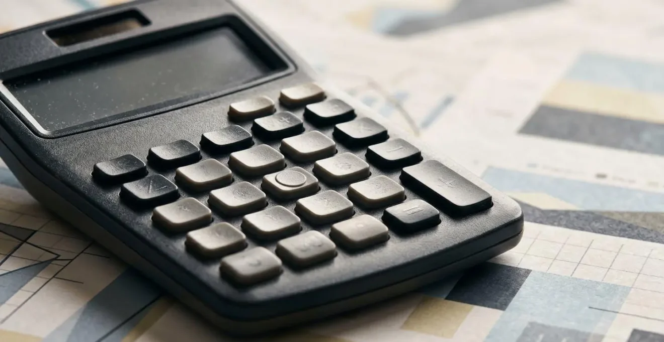 Gros plan sur une calculatrice et des documents financiers sur un bureau contemporain